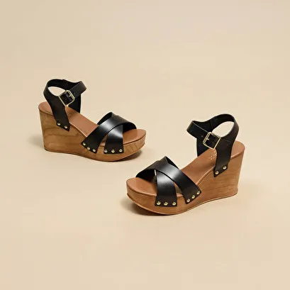 Wedge sandals with cross-over straps in black leather